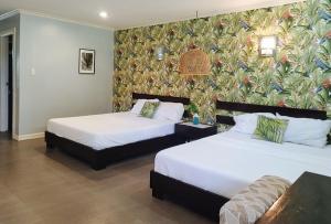 OtonRedDoorz @ Padi Beach Resort Oton Iloilo的壁画客房内的两张床