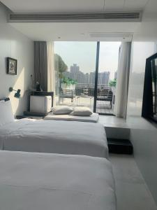 上海上海外滩盎格酒店的带大窗户的客房内的两张床