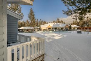 镭温泉RidgeView Resort的一座带围栏和雪盖的院子的房子