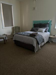 HardenThe Muddy Duck的一间卧室配有一张大床和绿色床头板