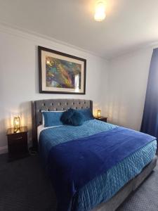 朗塞斯顿老面包房旅馆的一间卧室配有一张带蓝色棉被的床