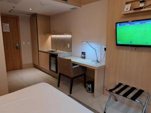 巴西利亚BSB STAY Flats particulares - CULLINAN的客房设有书桌和墙上的电视