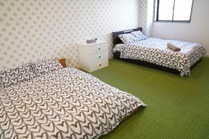 大阪心斎橋USJ155m2 Party OK JR駅徒歩1分的一间卧室配有两张床,铺有绿色地毯