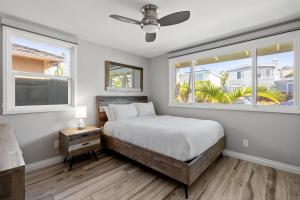 圣地亚哥Bird Rock Dreams - Ocean Views, Massive Yard, Outdoor Dining, Fast Wifi & AC!的一间卧室设有一张床和两个窗户。