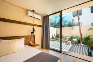 图卢姆Faisano Nomadas的一间卧室配有一张床,享有庭院的景色
