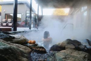 香取市THE FARM Resort Japan的一位妇女站在一个热水浴缸中,在一次有泡的手术医生手术中