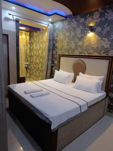 瓦拉纳西Rudraksha Inn的一间卧室配有一张带白色床单的大床