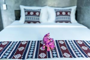 高兰Siam Lanta Resort - SHA Extra Plus的床上一对床,床上有一朵紫色的花