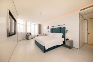 上海上海外滩盎格酒店的卧室配有白色的床和电视。