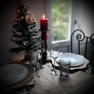 锡拉库扎acquarello的一张桌子,上面放着蜡烛和酒杯,还有圣诞树