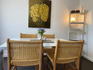 AngastonAngaston Mews Apartments的餐桌,配有两把椅子和一幅葡萄画