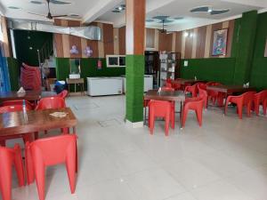 德拉敦Saukari Palace的一间设有红色桌椅和绿色墙壁的餐厅