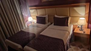 麦加شقق فندقية التلال的酒店客房设有两张床和两盏灯。
