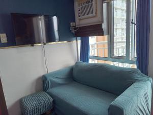 大雅台Tagaytay Prime Residences with Swimming Pool & Viewing Deck的窗户客房内的绿色沙发