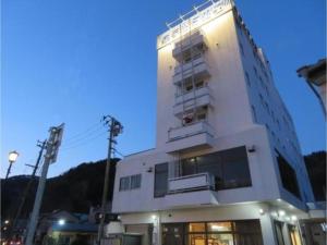 釜石Hotel Marue - Vacation STAY 78769v的一座高大的白色建筑,上面设有阳台