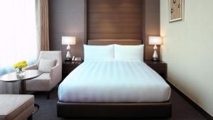首尔LOTTE City Hotel Gimpo Airport的配有一张床和一把椅子的酒店客房