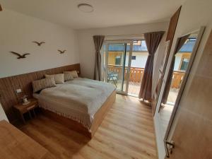 塞尔纳珀苏马维Apartmány - Malé Lipno的一间卧室设有一张床和一个阳台