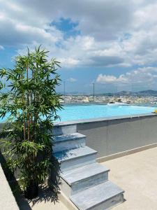 雅典NEW 2BDR apartment with SHARED ROOFTOP POOL的一座带楼梯的游泳池,旁边是一座植物