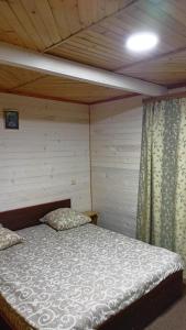 亚列姆切Відпочинок у Євгена та Оксани的木天花板的客房内的一张床位