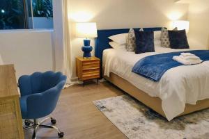 SylvaniaKing Bedroom Waterfront Courtyard Apartment的一间卧室配有一张床和一张蓝色椅子