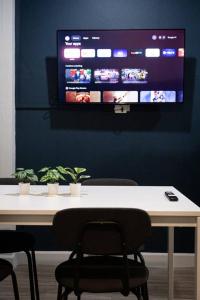 曼谷A2 Comfortable space wt Kitchen的桌椅和墙上的电视