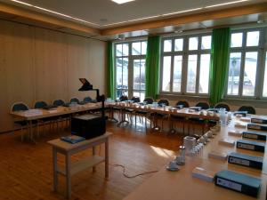 巴特阿巴赫Deutenhof Hotel, Restaurant & Veranstaltung的一间设有一排桌椅和绿色窗帘的房间