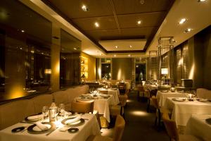 格拉纳达奥妮莉亚别墅酒店的餐厅配有桌椅和白色桌子
