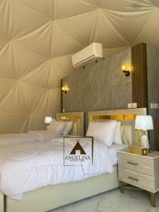 亚喀巴Angelina Luxury Camp的卧室内的两张床和帐篷