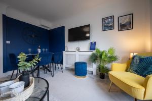 坎特伯雷The Copperfield - Modern 4 Bed house with parking的一间拥有蓝色墙壁的客厅和一间餐厅