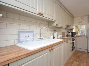 马托克3 bed in Martock 51722的厨房配有白色橱柜和水槽
