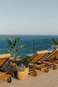 圣埃乌拉利亚Melia Ibiza - Adults Only的一个带椅子和盆栽的甲板和大海