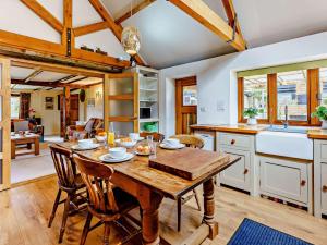迪姆彻奇3 bed property in Aldington 54088的厨房以及带木桌和椅子的用餐室。