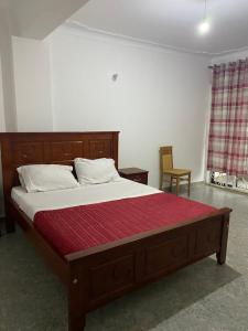NamugongoIngrid's Place - Namugongo的一间卧室配有一张带红色床垫的大床