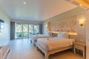 纳泰海滩The Hotspring Beach Resort & Spa - SHA Extra Plus的一间卧室设有两张床和大窗户