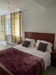 NamugongoIngrid's Place - Namugongo的一间卧室配有一张大床和两个枕头