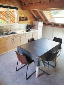 勒布罗伊斯WhispeRive Lodge - le vert aux bords de rive的厨房配有黑色的桌子和椅子