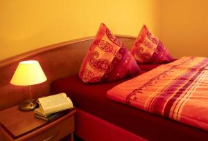 卡尔斯哈根Haus Meerjungfrau的一间卧室,配有一张带灯和书籍的床