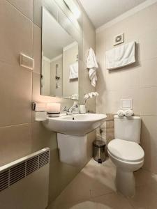 拉兹洛格Spacious penthouse chalet apartment in Pirin Golf and Country Club的一间带水槽、卫生间和镜子的浴室