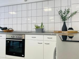 凯沃拉尔Monteurzimmer in Kevelaer的厨房配有白色橱柜和黑烤箱。