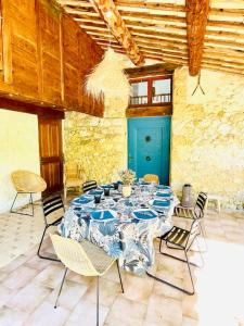 CondorcetMas Provençal en Drôme的配有桌椅和蓝色门的房间