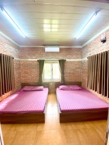 河内Lều biệt thự的配有粉红色床单的客房内的两张床