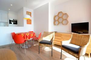 莱斯卡拉Apartamentos Passeig Del Mar的客厅配有桌椅和电视。