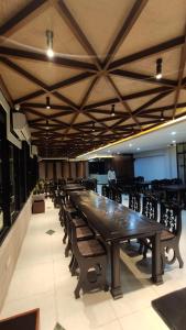 巴纳内拉斯Hotel Grand Akther Sylhet的大型会议室,配有长桌子和椅子