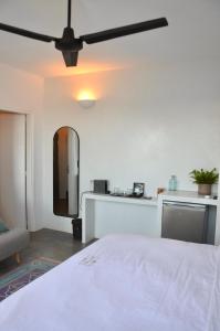 PerástraRoyal-Ma Resort的卧室配有白色的床和吊扇