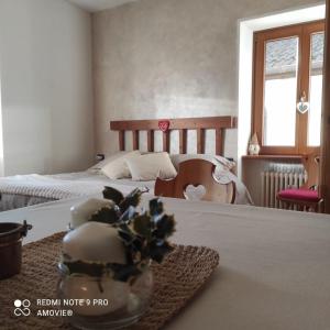 卡斯泰洛泰西诺Casa Gaudia的一间卧室设有两张床和一张带花盘的桌子。