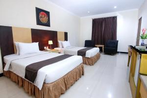 北加浪岸Parkside Mandarin Hotel Pekalongan的酒店客房设有两张床和电视。