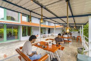 蓬蒂切里Zostel Pondicherry, Auroville Road的一群坐在餐厅桌子上的人