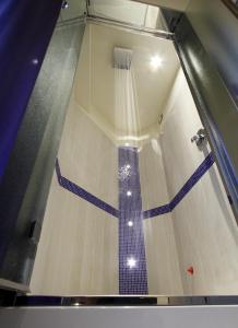 雷诺河畔卡萨莱基奥卡尔扎维切诺精品酒店的铺有蓝色和白色瓷砖地板的淋浴