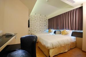 台北欣欣旅店的酒店客房,配有两张床和椅子