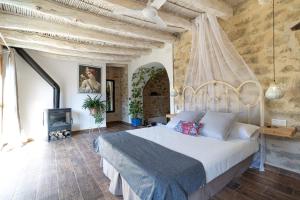 PatróCasa rural Vall de Gallinera con Chimenea, piscina y jacuzzi DIANIA的一间卧室设有一张大床和一个壁炉